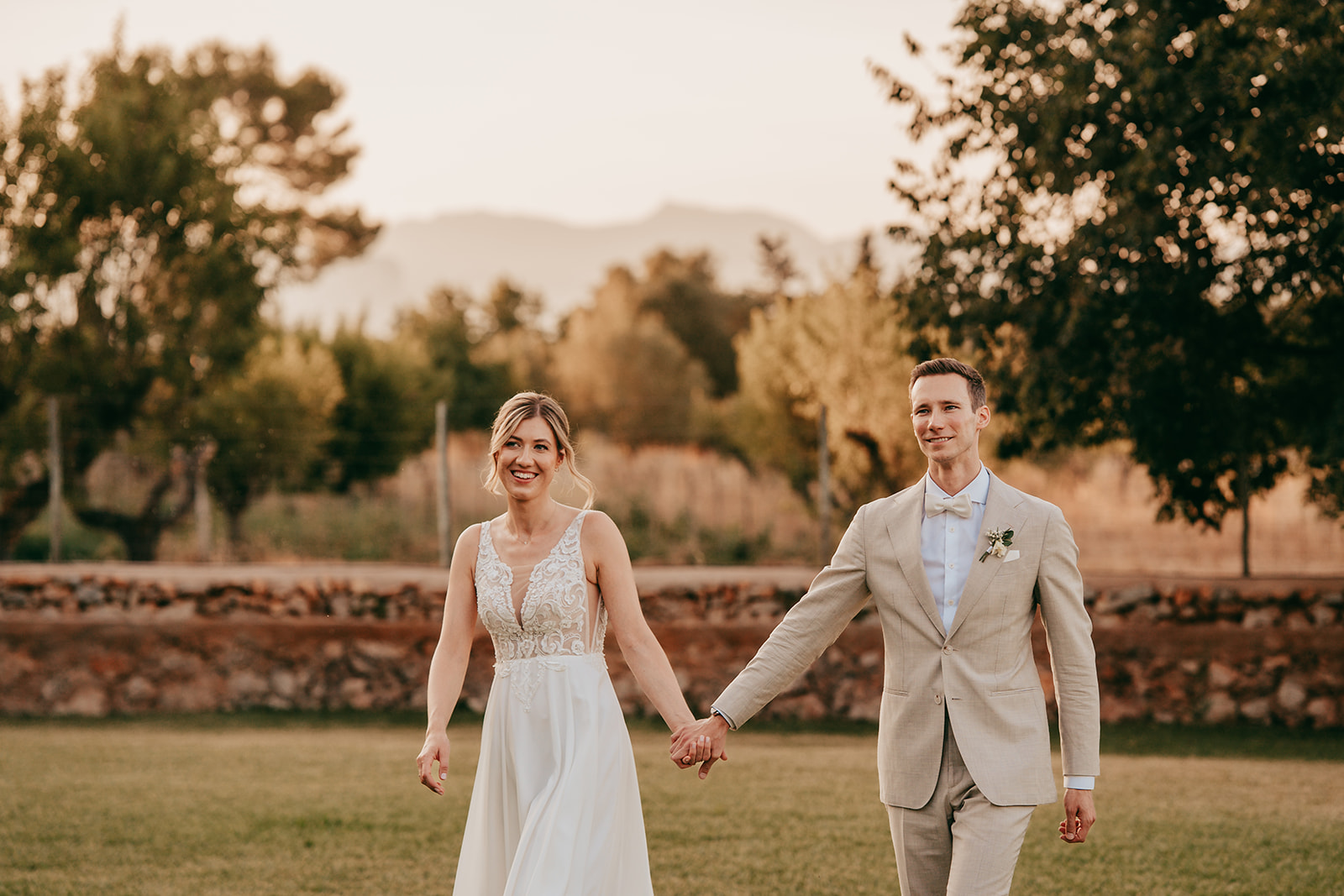 conny und marcel: finca alaiar a man and woman holding hands and walking on grass